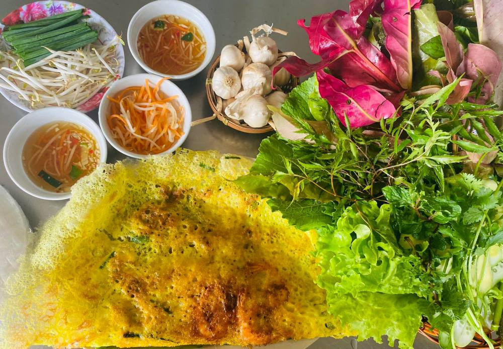 Bánh xèo rau rừng A Đạt, nổi bật với phần rau rừng đa dạng, là điểm đến ẩm thực Gò Vấp độc đáo