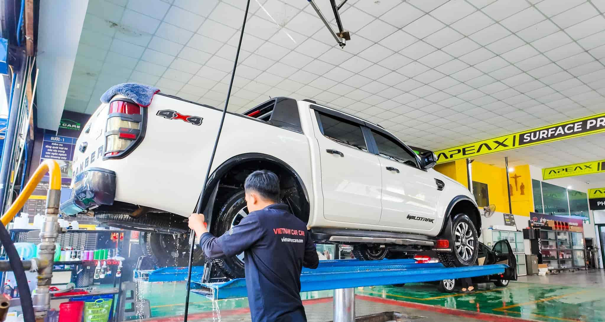 Bước xịt rửa gầm xe ô tô chuyên nghiệp trước khi làm sạch thân xe.
