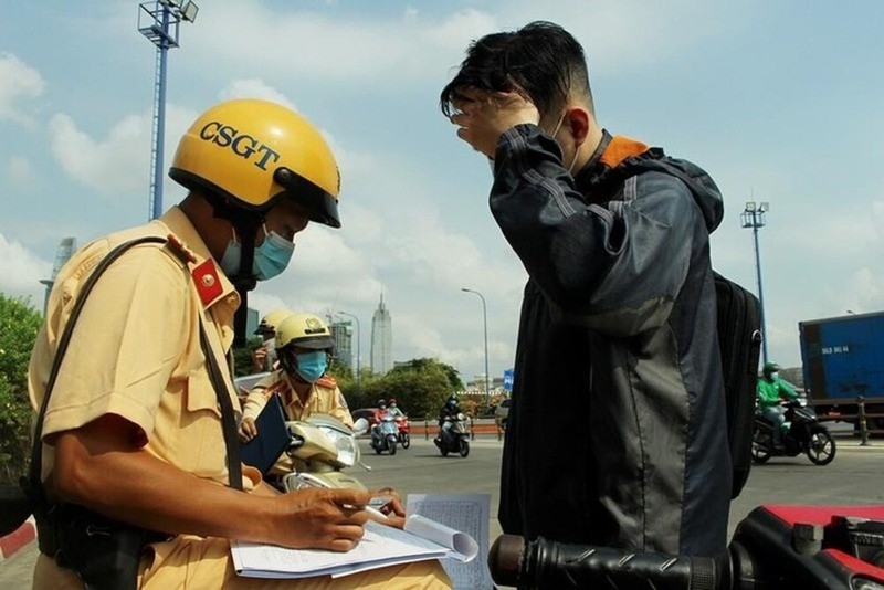 Cán bộ cảnh sát giao thông kiểm tra giấy tờ xe máy bao gồm bảo hiểm