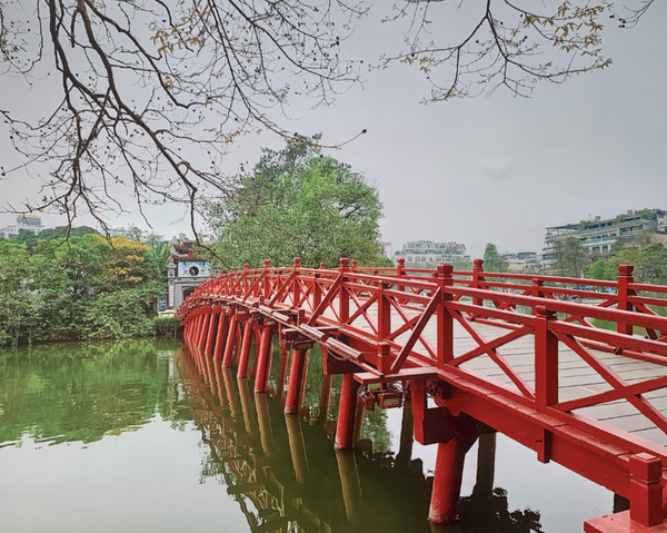 Cầu Thê Húc màu đỏ tươi nối bờ hồ với đền Ngọc Sơn, là điểm nhấn kiến trúc nổi bật của hồ Hoàn Kiếm Hà Nội.
