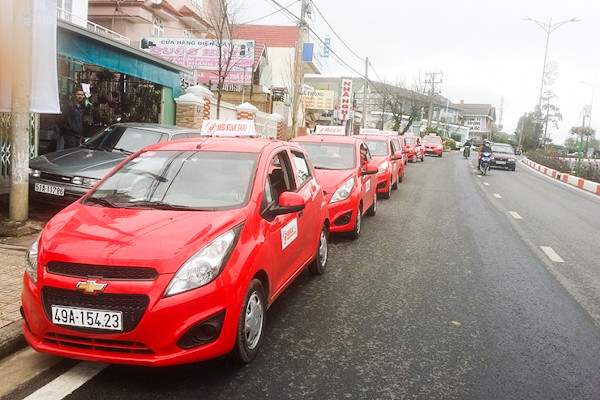 Chiếc xe taxi Sao Đỏ màu đỏ nổi bật trên đường phố Tây Ninh, biểu tượng của dịch vụ vận chuyển uy tín.