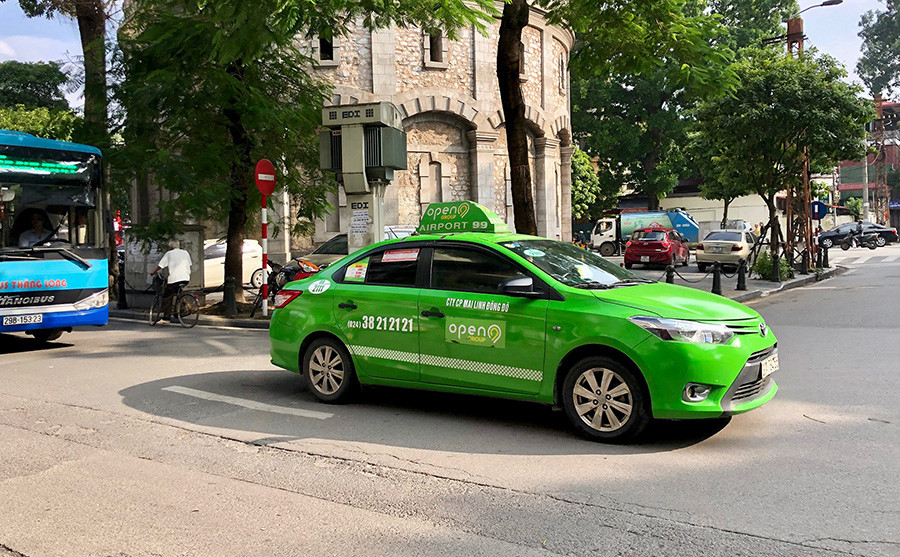 Dàn xe taxi Open99 Bến Tre màu xanh lá hiện đại đang chờ đón khách, thể hiện sự đa dạng của dịch vụ taxi Bến Tre
