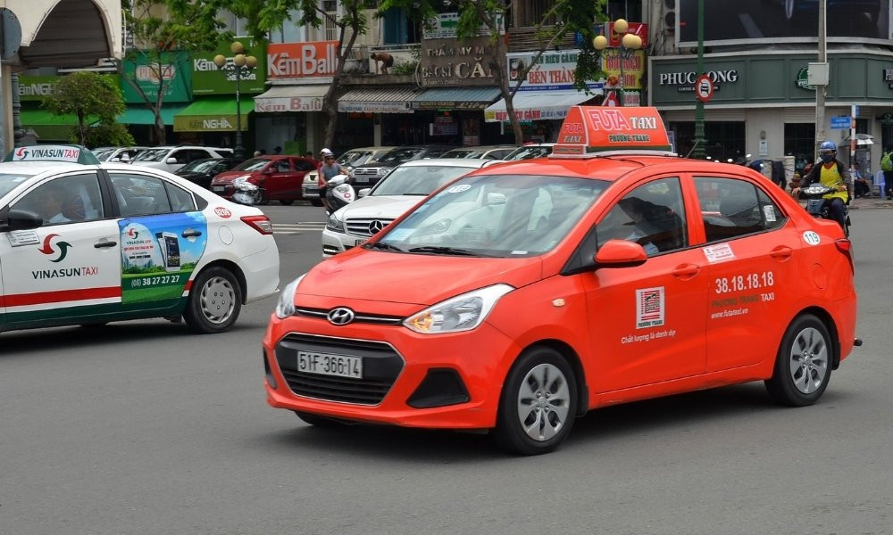 Dòng xe taxi Phương Trang màu cam nổi bật trên đường phố Sài Gòn tấp nập