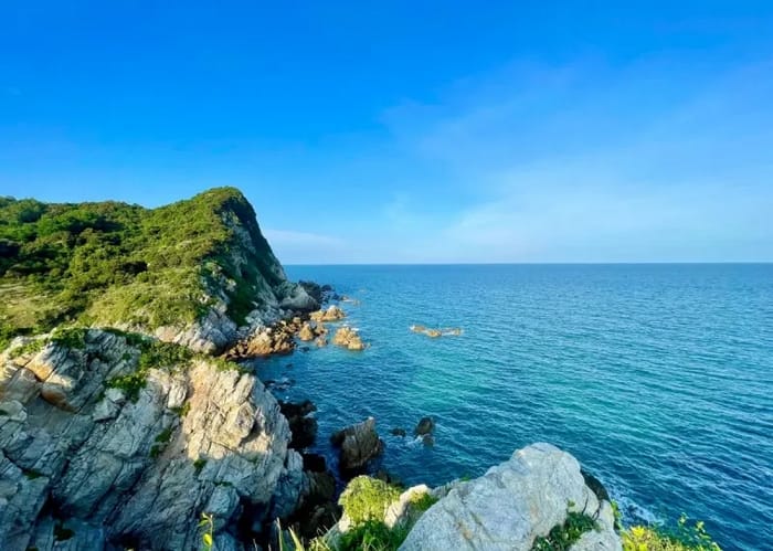 Eo Gió Quan Lạn là một dải núi đá sát bên bờ biển lặng và một bên là rừng xanh