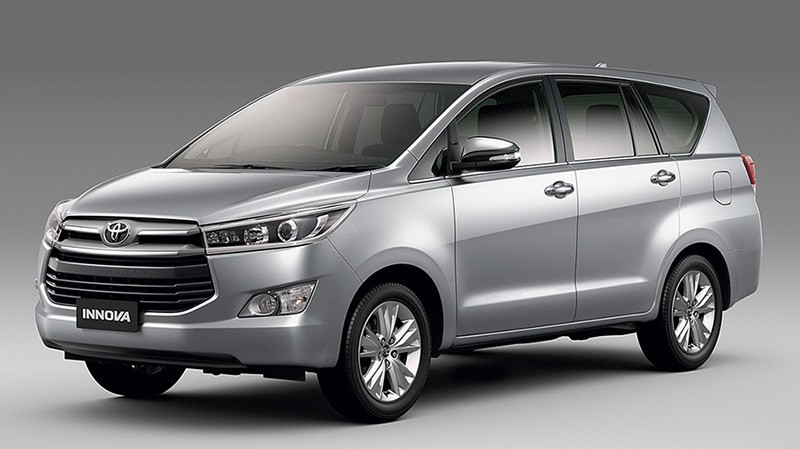 Hình ảnh một chiếc taxi 7 chỗ hiện đại màu bạc đang chờ đón khách, thể hiện không gian rộng rãi và tiện nghi cho các chuyến đi dài.
