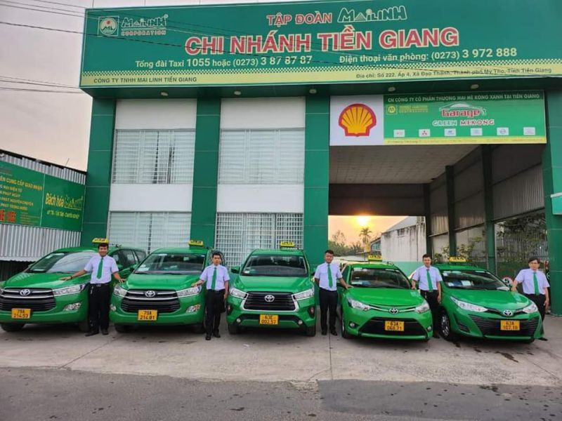 Hình ảnh xe taxi Mai Linh màu xanh lá cây đang di chuyển trên đường phố Tiền Giang