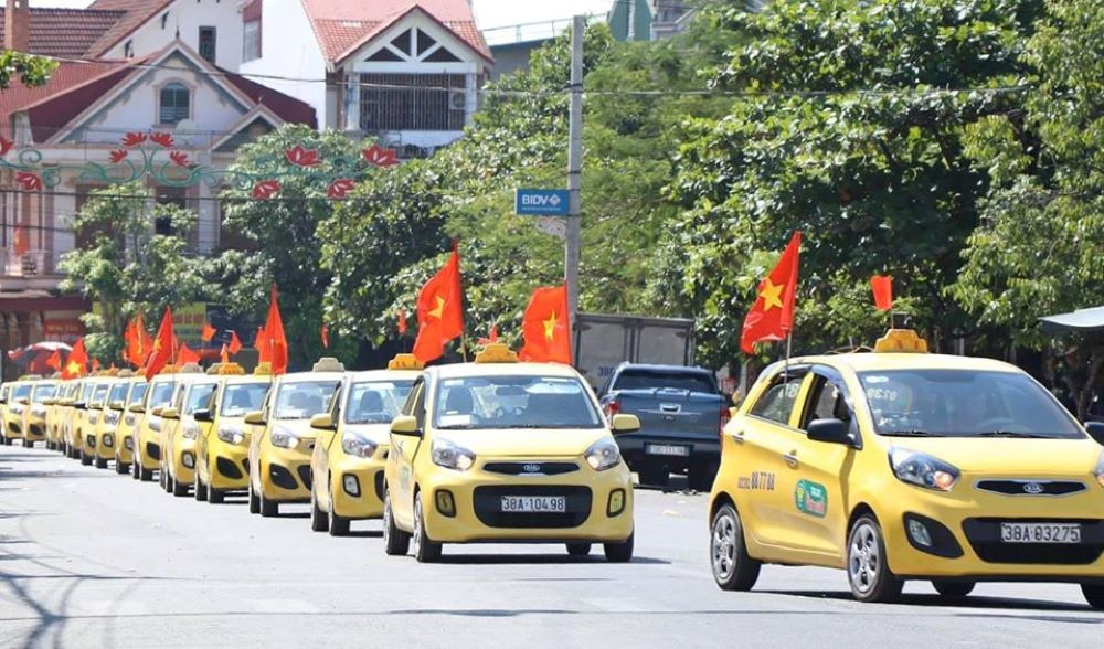 Hình ảnh xe taxi Phú Thành màu trắng đang đỗ trên đường