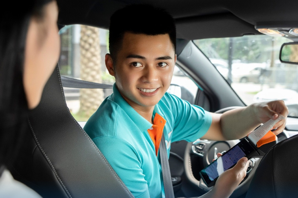 Khách hàng sử dụng máy POS để thanh toán cước phí taxi Xanh SM, mang lại sự tiện lợi và hiện đại