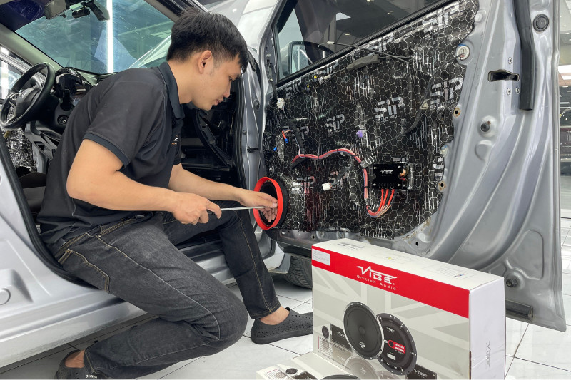 Kỹ thuật viên đang thi công lắp đặt âm thanh cho xe hơi