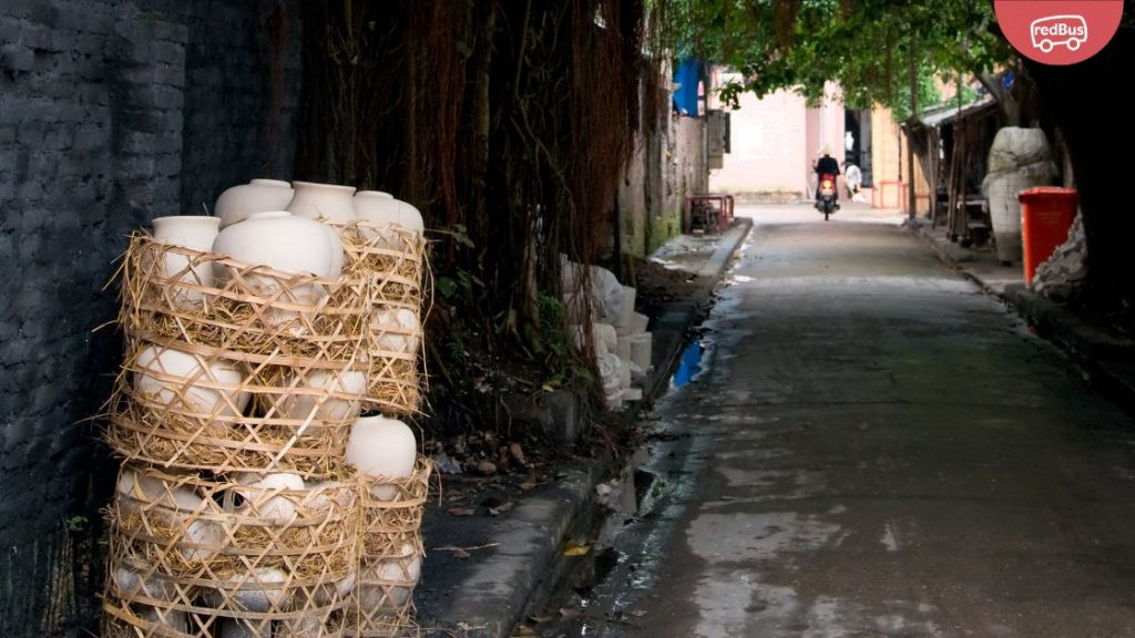 Lối đi nhỏ lát gạch giữa những ngôi nhà cổ kính tại làng gốm Bát Tràng, thể hiện kiến trúc truyền thống của làng nghề.