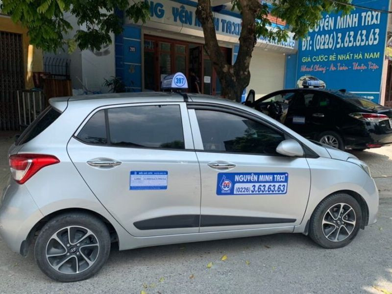 Một chiếc taxi Nguyên Minh màu trắng, đại diện cho sự tiện lợi của dịch vụ taxi ở Hà Nam