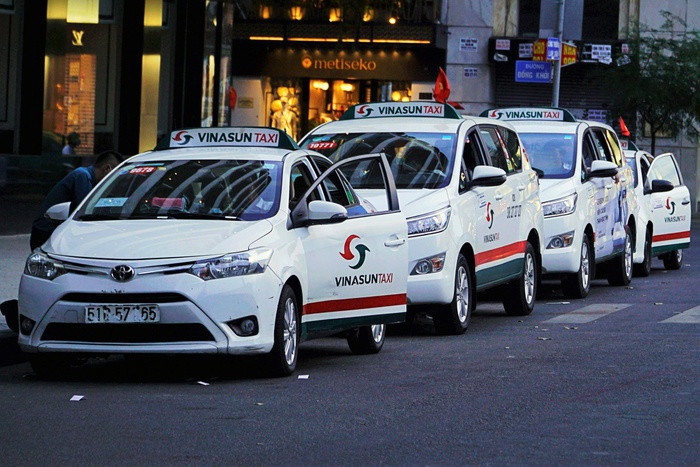 Một chiếc taxi Vinasun màu trắng xanh đang chờ khách hàng