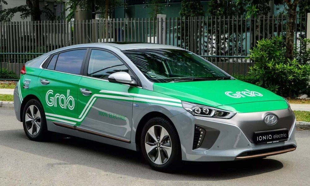 Một chiếc xe Grab màu xanh lá cây đang chờ đón khách trên đường phố Sài Gòn