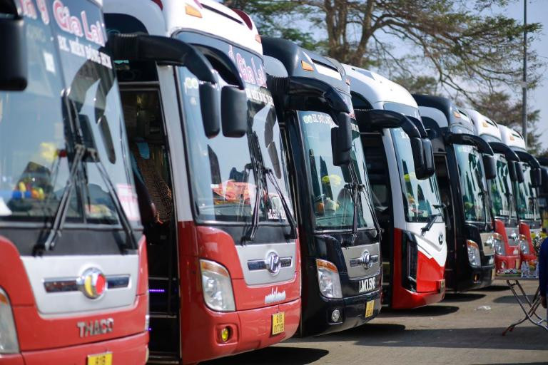 Một chiếc xe khách Thuận Ý đang dừng nghỉ dọc đường, tài xế đang kiểm tra lốp xe
