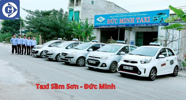 Một chiếc xe taxi màu trắng với logo Đức Minh di chuyển trên đường ven biển Sầm Sơn