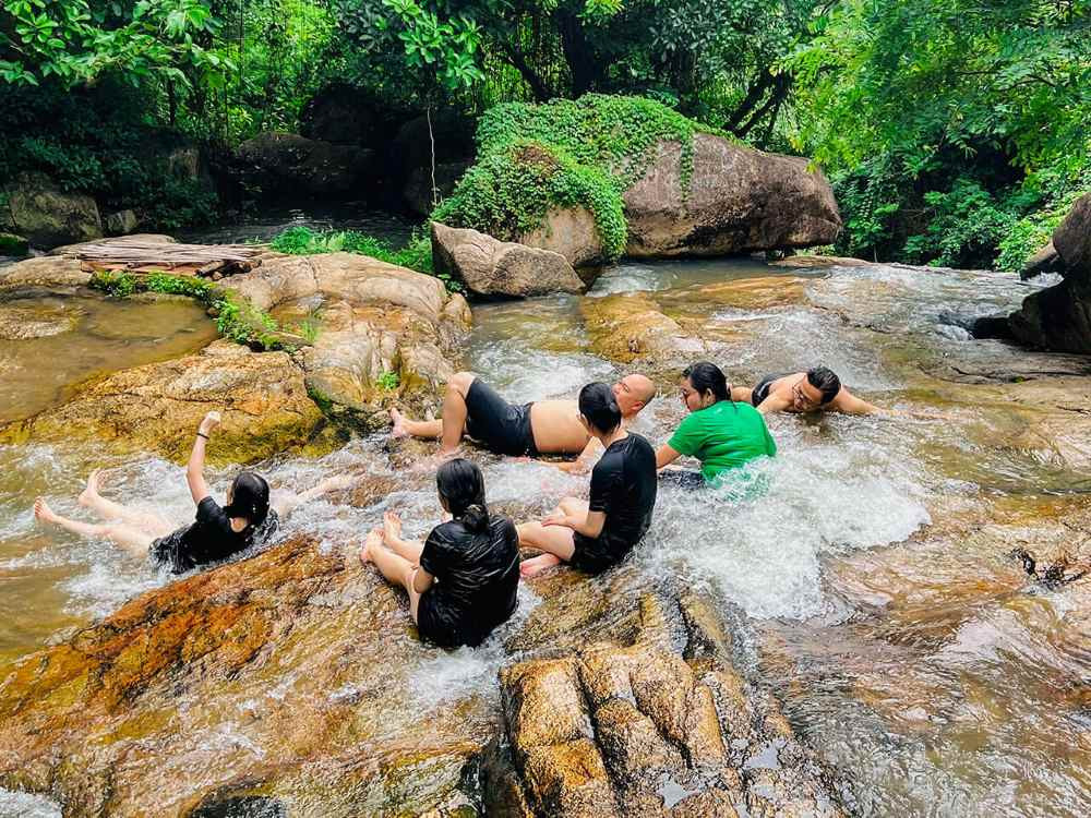 Một nhóm người đang tắm mát và thư giãn tại suối Hố Trời