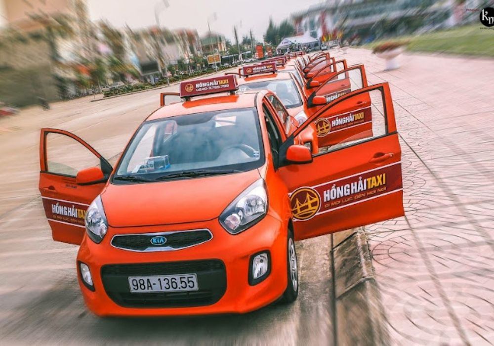 Một tài xế taxi Hồng Hải thân thiện đang mở cửa xe, thể hiện dịch vụ tận tâm tại Hiệp Hòa Bắc Giang