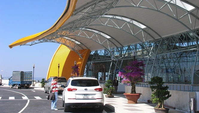 Người đàn ông đang xem điện thoại tại sân bay, minh họa việc tìm kiếm thông tin và kinh nghiệm di chuyển taxi don duong san bay