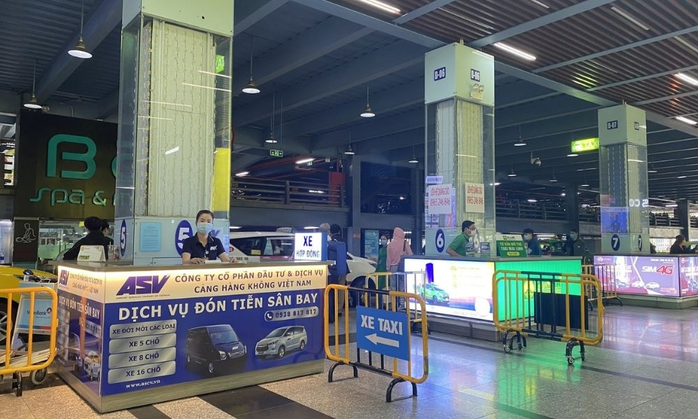 Quầy dịch vụ taxi ASV Airports tại sân bay, với nhân viên đang tư vấn cho khách hàng