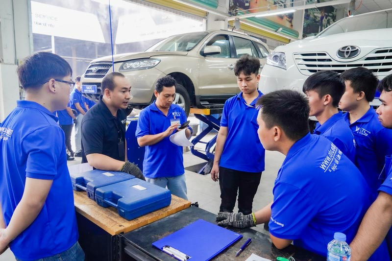 Sinh viên thực hành học nghề sửa ô tô trong xưởng.