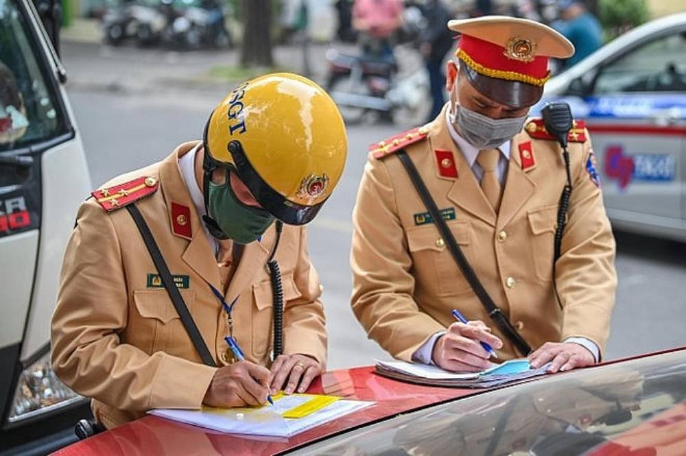 Tài xế đang xem xét biên bản vi phạm giao thông cùng cảnh sát