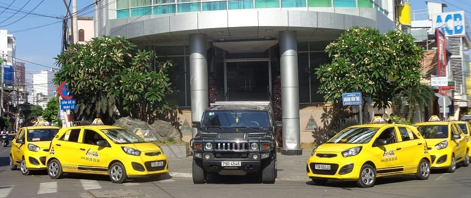 taxi asia nha trang màu vàng đang chạy trên đường phố