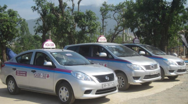 Taxi Hoa Sim Kỳ Anh với chiếc xe màu trắng đang di chuyển trên đường