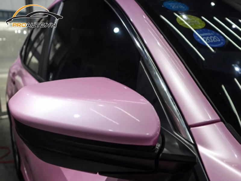 Thợ chuyên nghiệp đang hoàn thiện lớp wrap đổi màu trên xe Hyundai Accent.