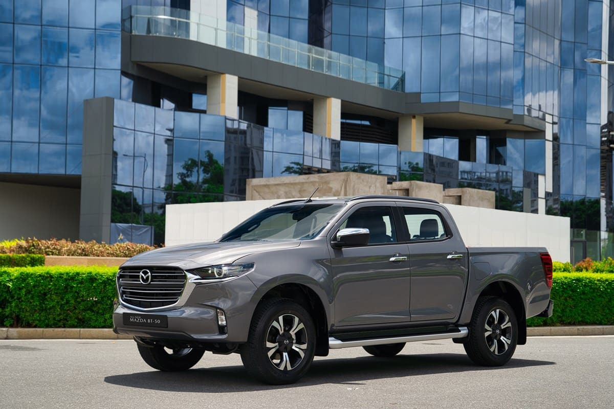 Xe bán tải Mazda BT-50 màu xanh chạy trên địa hình đất, thể hiện khả năng vận hành mạnh mẽ