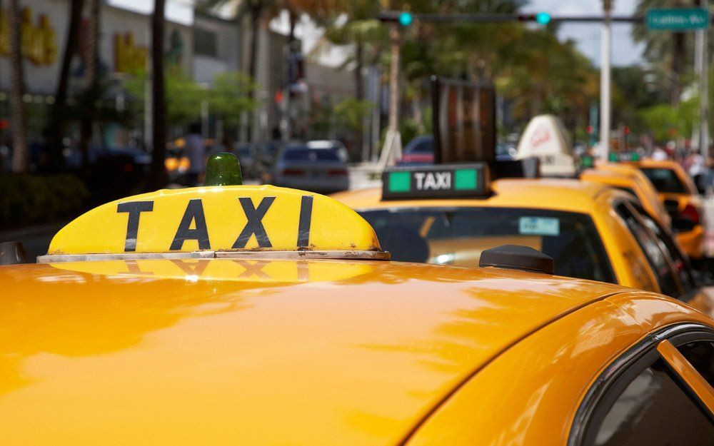 Xe taxi đang chạy trên đường tại một thành phố sầm uất, biểu tượng cho việc di chuyển thuận tiện bằng taxi tại Sơn Tây