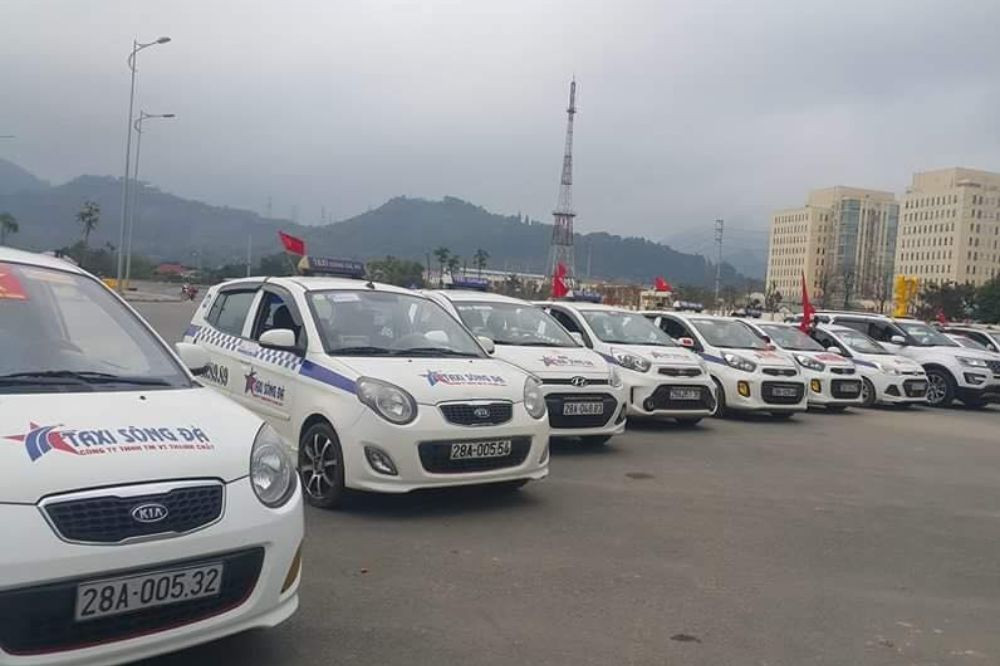 Xe taxi điện Xanh SM đang chờ khách tại một khu vực công cộng ở Hòa Bình, biểu tượng cho sự phát triển của taxi xanh