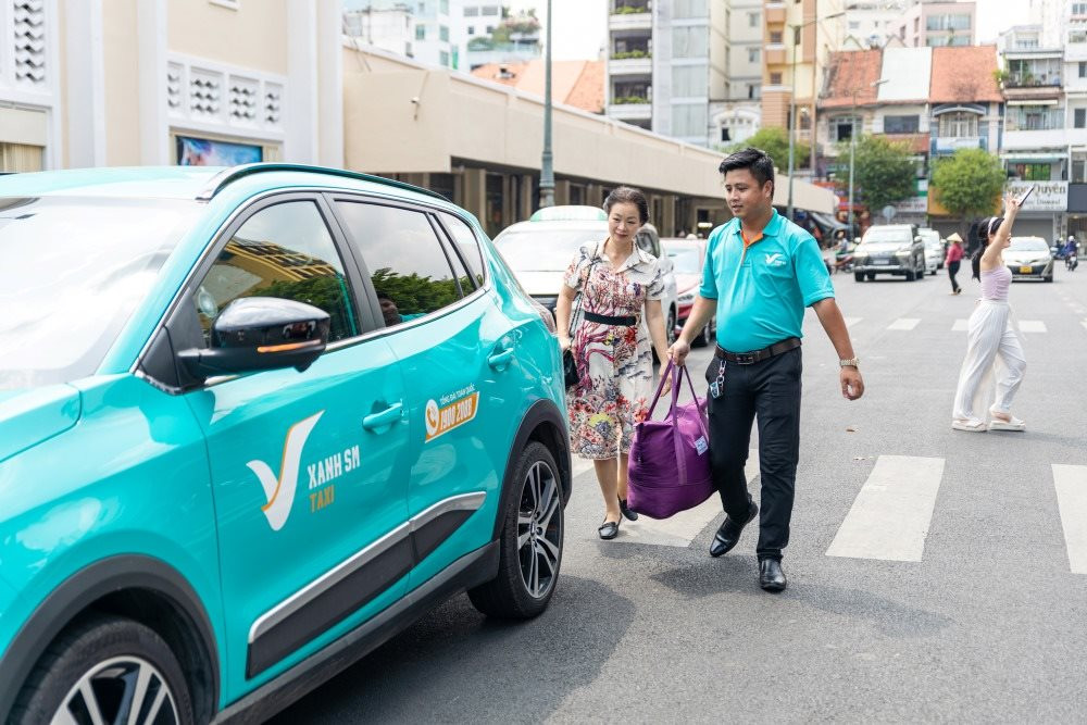 Xe taxi điện Xanh SM màu xanh ngọc đậu tại sân bay, sẵn sàng phục vụ khách hàng