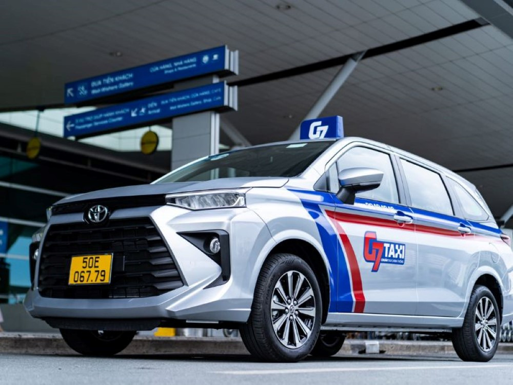 Xe taxi G7 màu trắng với logo số 7 nổi bật trên đường