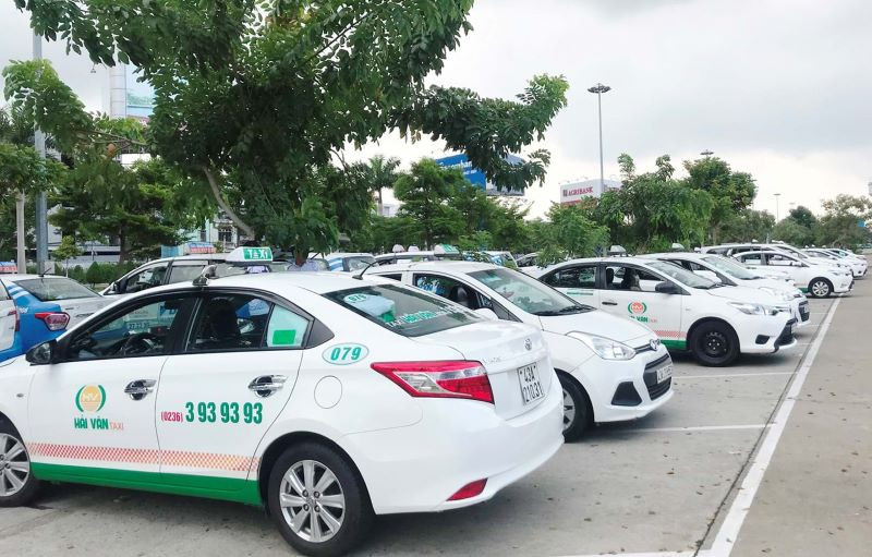 Xe taxi Hải Vân màu trắng đang di chuyển qua một con đường đông đúc ở Đà Nẵng