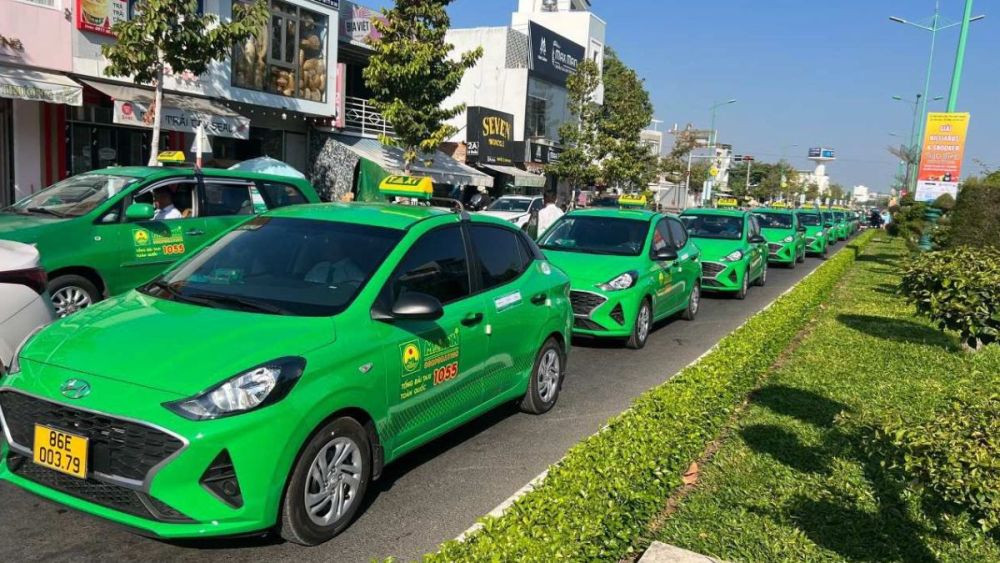 Xe Taxi Mai Linh màu xanh đặc trưng hoạt động vào ban đêm trên đường phố