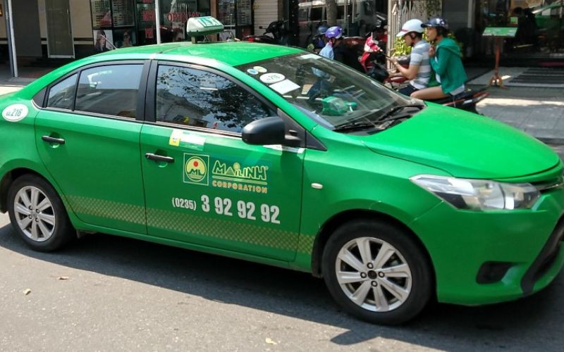 Xe taxi Mai Linh màu xanh lá cây đặc trưng trên phố Hà Nội, biểu tượng của dịch vụ vận tải