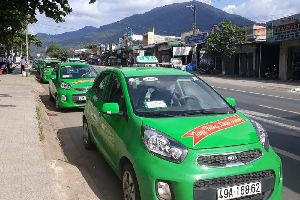 Xe taxi Mai Linh màu xanh lá đặc trưng đang đỗ bên đường, sẵn sàng phục vụ hành khách