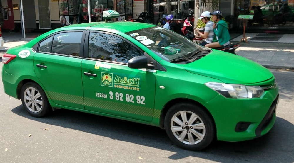 Xe taxi Mai Linh màu xanh lá đặc trưng, di chuyển trên đường phố