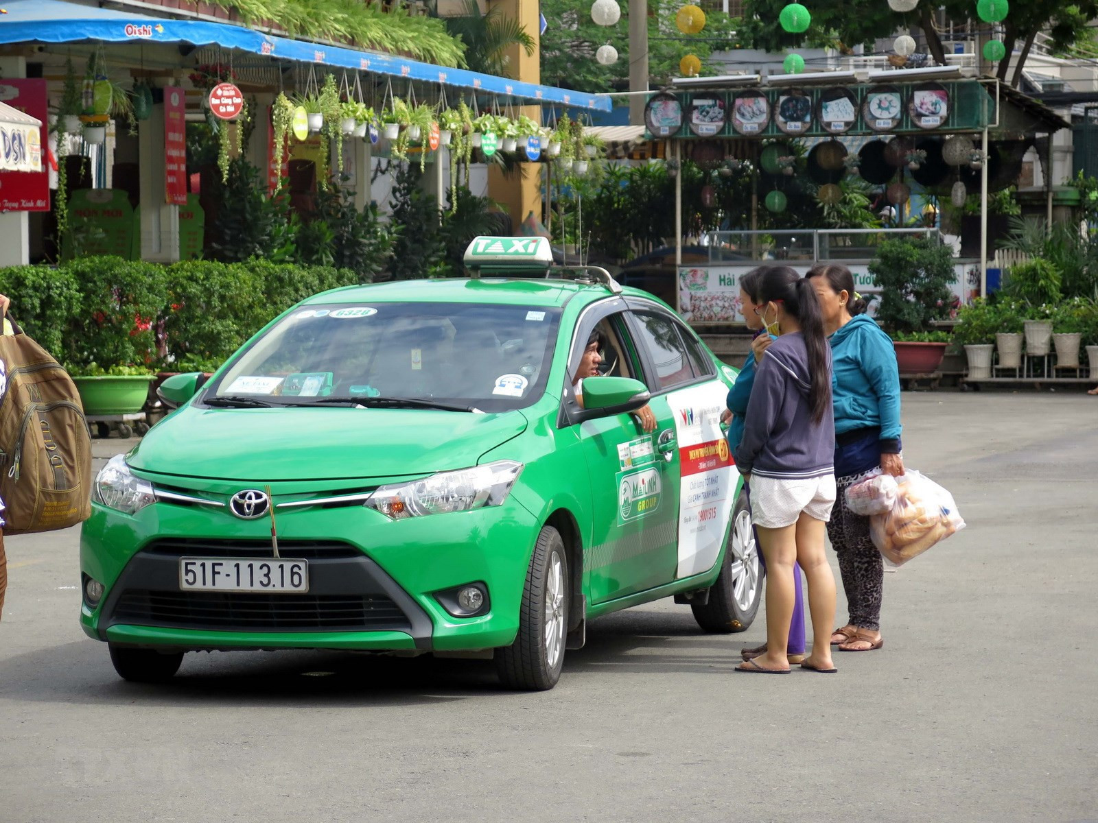 Xe taxi Mai Linh màu xanh lá đậu trên đường ở Vĩnh Long