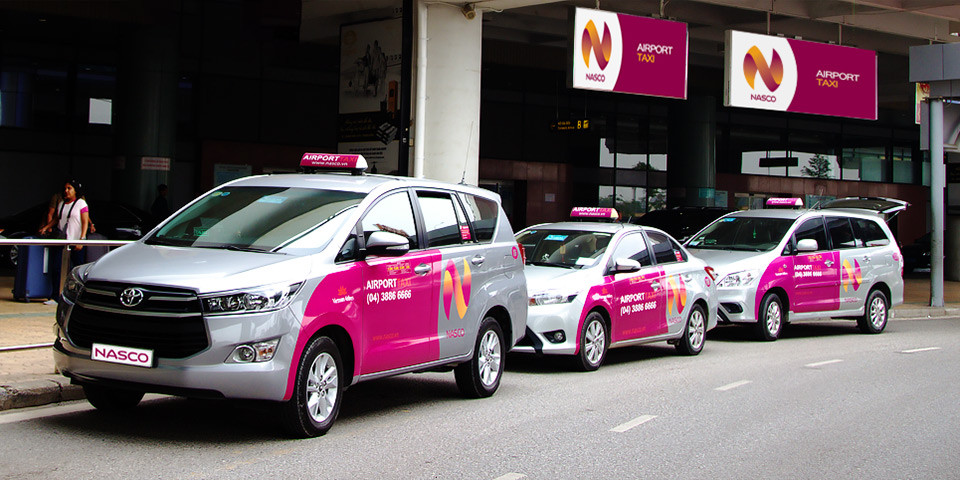 Xe taxi màu xanh di chuyển trên đường tại Huyện Buôn Đôn