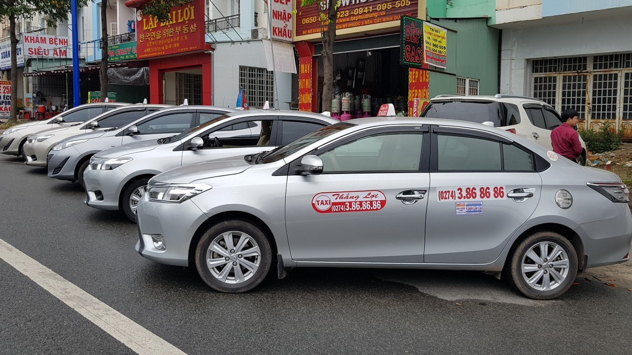 Xe Taxi Thắng Lợi màu xám đang chạy trên đường