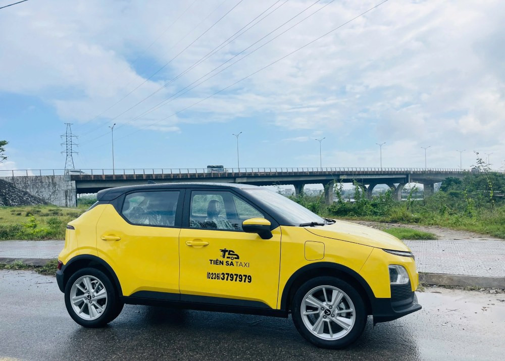 Xe taxi Tiên Sa điện VinFast VF5 Plus màu trắng đậu trên phố Tam Kỳ, biểu tượng của di chuyển xanh