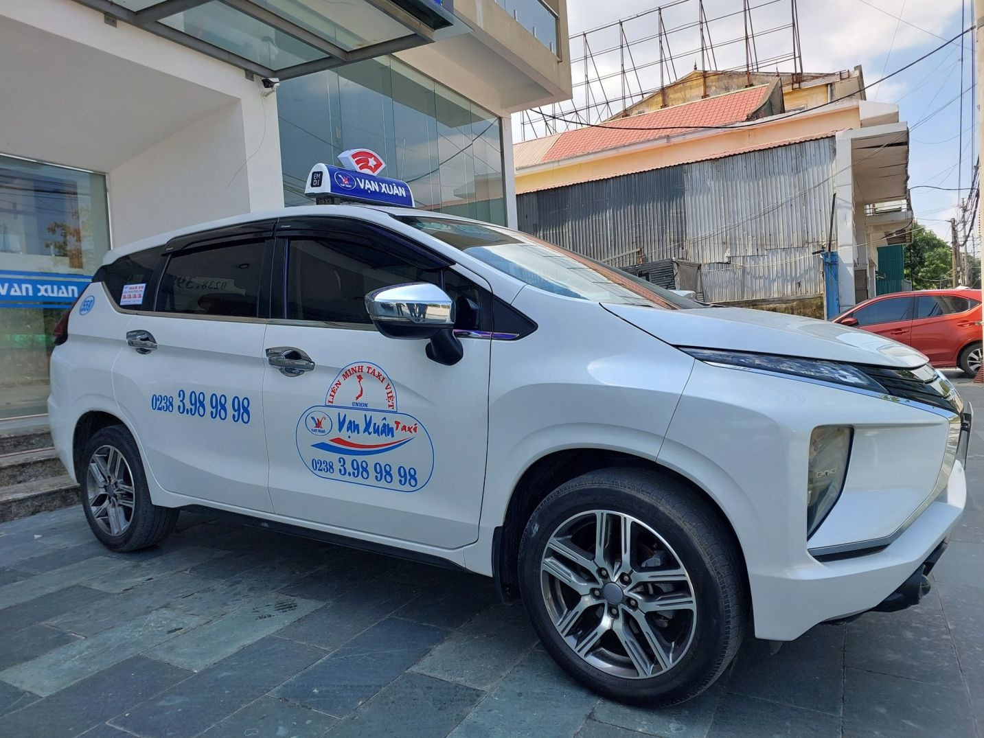 Xe taxi Vạn Xuân màu xanh dương trên đường phố