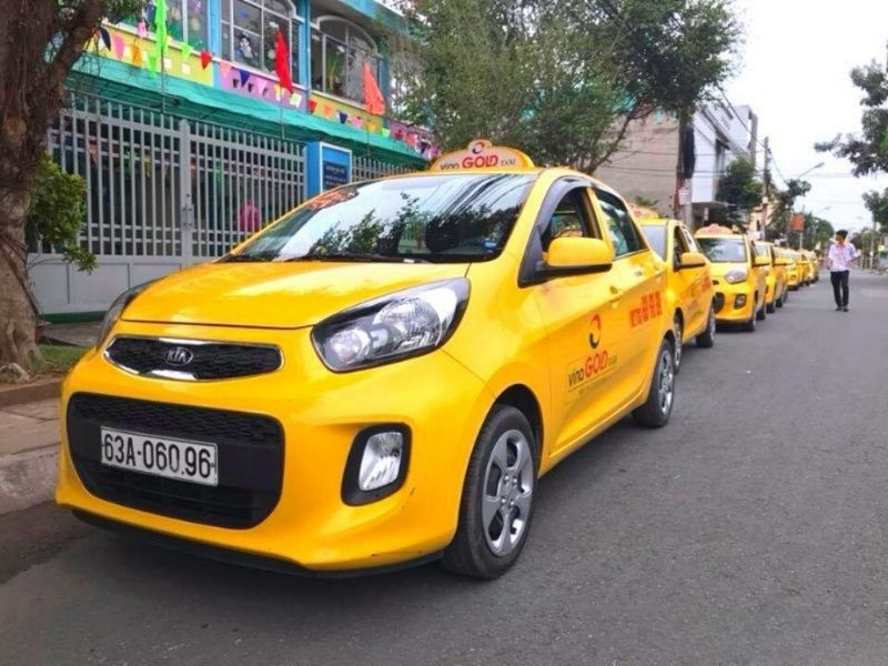 Xe taxi Vina Gold màu vàng nổi bật, minh họa cho dịch vụ **taxi chất lượng cao** tại Tiền Giang