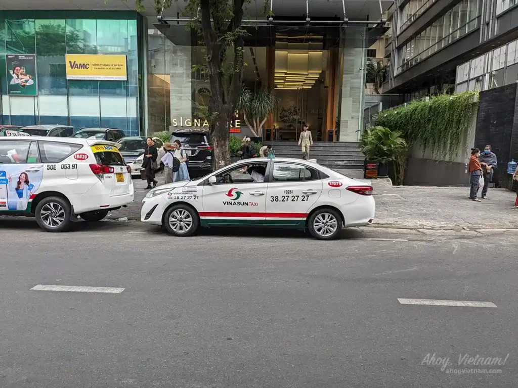 Xe taxi Vinasun màu trắng đậu gần khách sạn ở TP.HCM