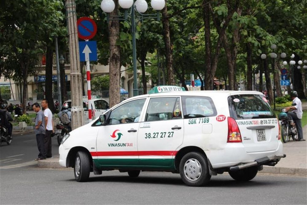 Xe taxi Vinasun màu trắng xanh quen thuộc đang lưu thông trên đường tại Tân Biên